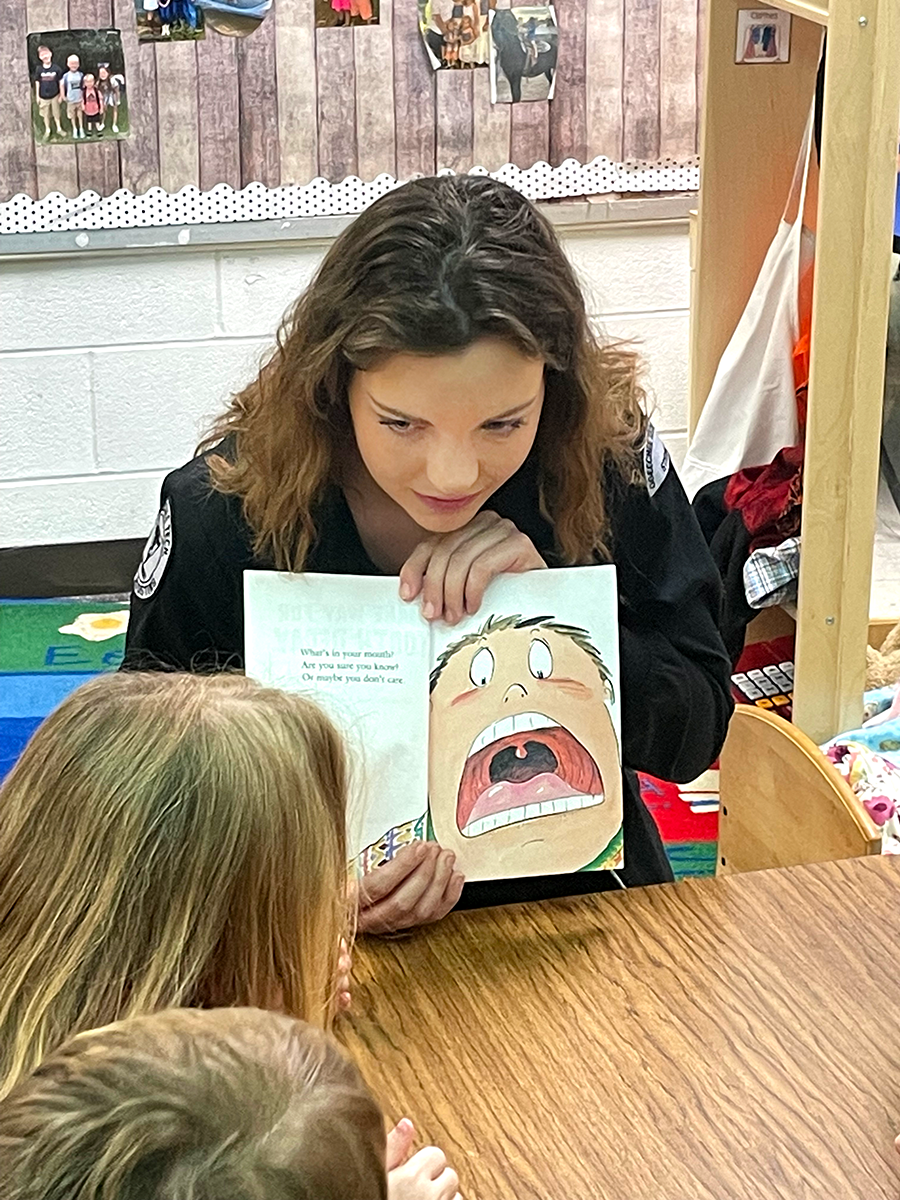 Dental Assisting student reading to students in Pre-K Classroom